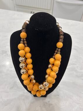 Yellow metal beaded multi-strand necklace with gold-tone chain.